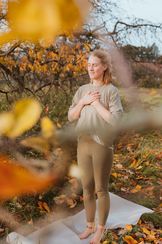 Frau hält Hände aufs Herz im herbstlichen Garten – Business Portrait Darmstadt