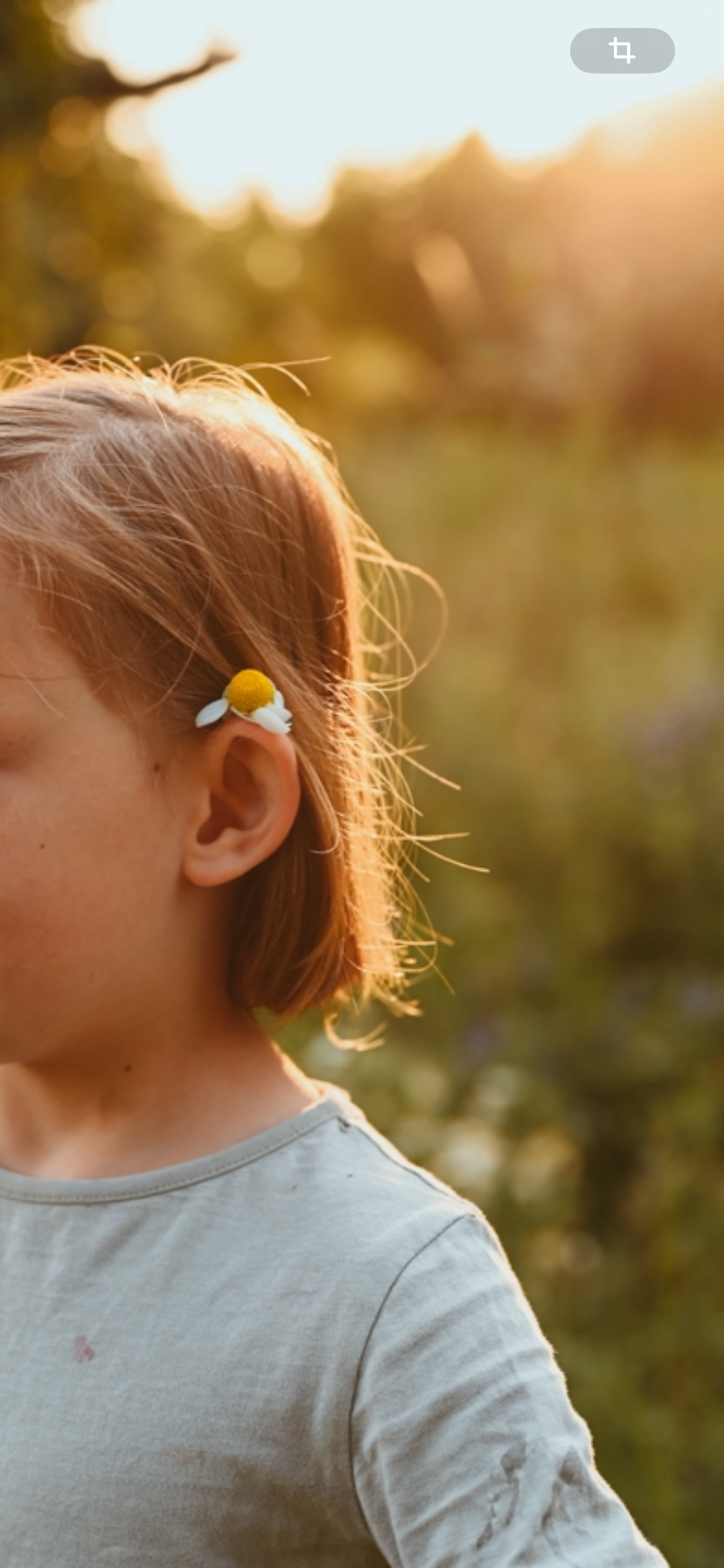 Lea, Tochter von Mareen Zimmermann, mit Gänseblümchen im Haar im warmen Gegenlicht – Namensinspiration MALEA Fotografie