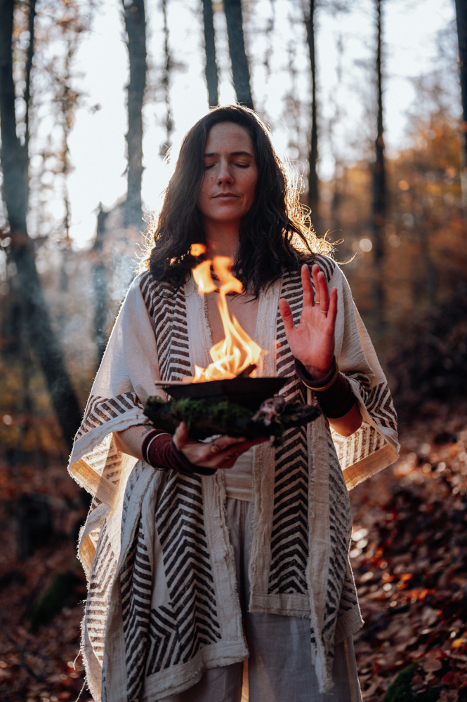 Frau hält brennende Schale im Herbstwald – kraftvolles Seelenfotografie Portrait