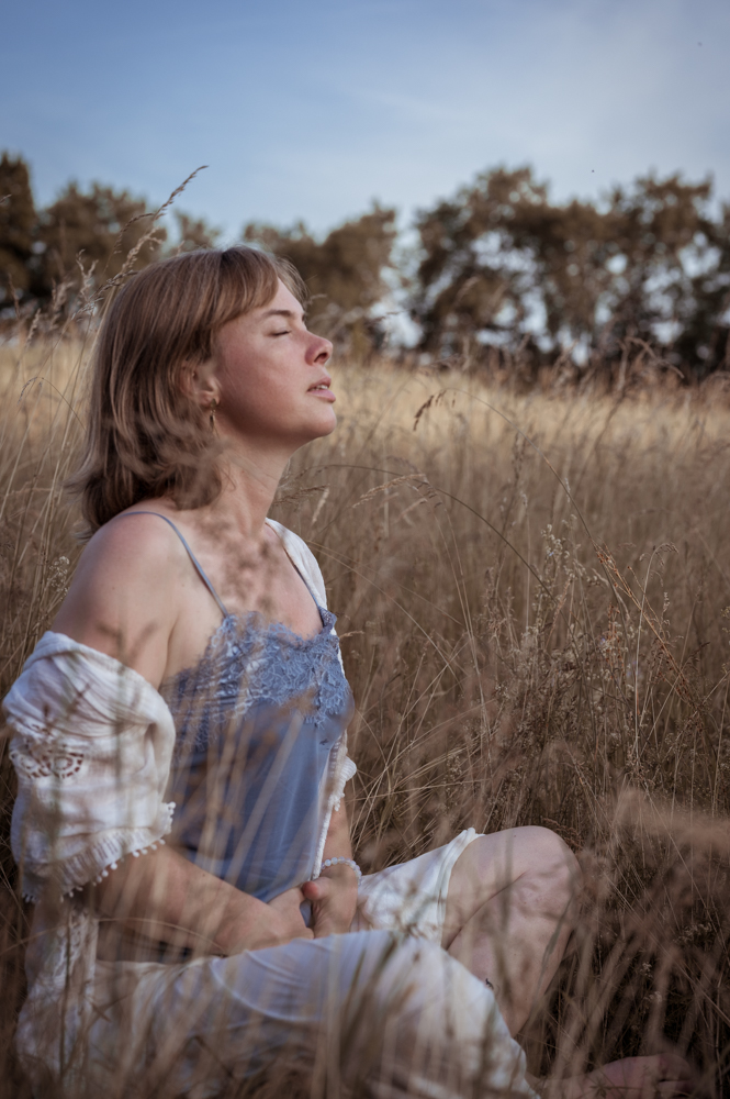 Frau sitzt meditierend im goldenen Feld, Augen geschlossen, blaues Kleid – Seelenfotografie von MALEA Fotografie Darmstadt
